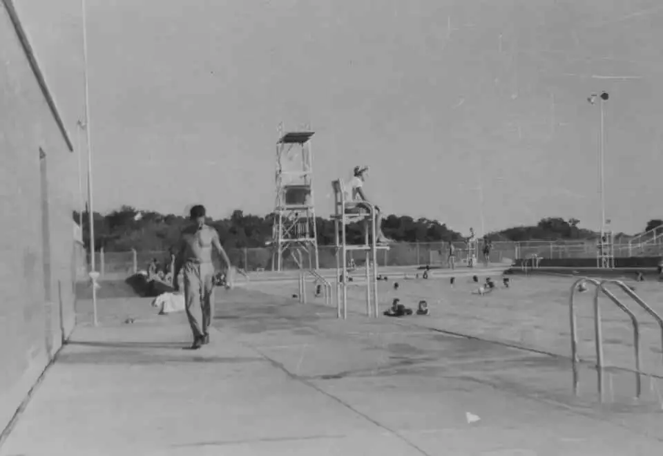 Black-and-white photograph of a lifeguard stand beside the pool